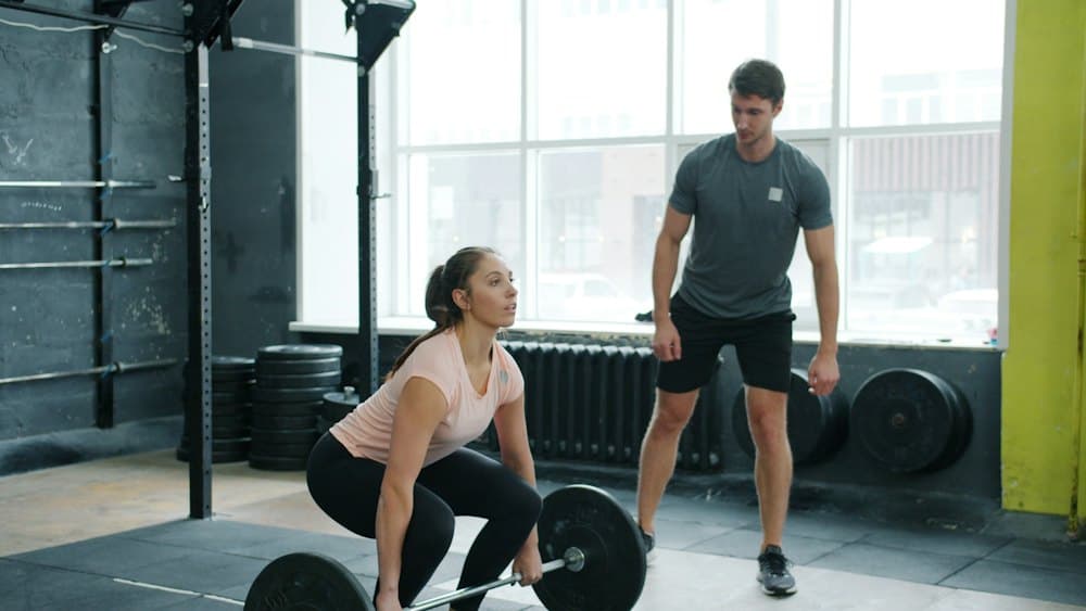 Coach watching an athlete deadlift